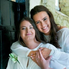Same sex Buckinghamshire wedding photography of the bride and bride enjoying a hug at their Missenden Abbey wedding
