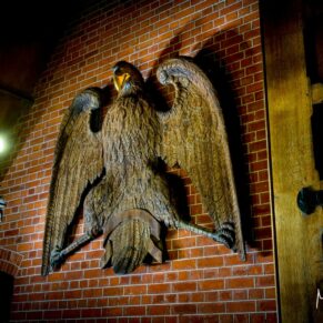 The huge carved eagle dramatically lit inside the grand entrance of The Dairy on the Waddesdon Estate