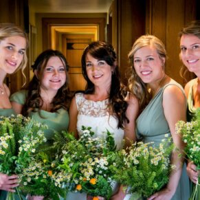 The bride with her bridesmaids gather for a window lit portrait before the civil ceremony at The Dairy