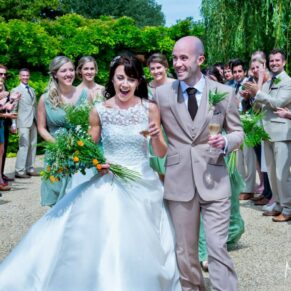 The newlyweds are cheered through their reception aisle on their wedding day at The Dairy