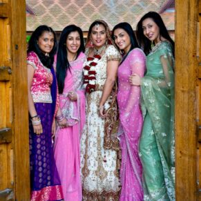 The Asian bride with her colourful bridesmaids in the entrance doorway at The Dairy for this magical wedding