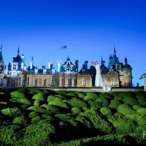 The newlyweds pose for the camera for this striking and dramatic floodlit shot taken at Waddesdon Manor