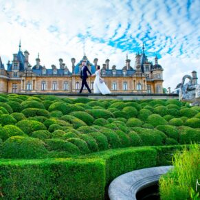 The newlyweds take a stroll hand in hand along the Parterre at Waddesdon Manor under dramatic skies