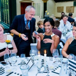 Paul Megram magician performing his tricks around a table of appreciative and lively guests