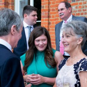 Candid moment between guests captured during the drinks reception in the gardens