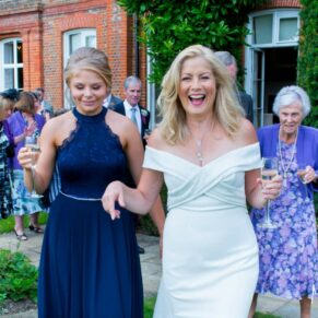 The bride strolling along with her bridesmaid within the stunning gardens