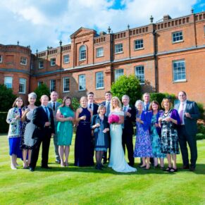 Larger family group pose on the lawns of the hotel