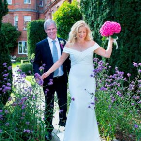 The newlyweds navigating through the flower borders at the 5 star venue