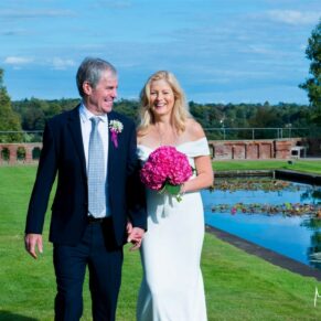 The newlyweds enjoying a stroll in the sunshine on their wedding day at The Grove in Watford