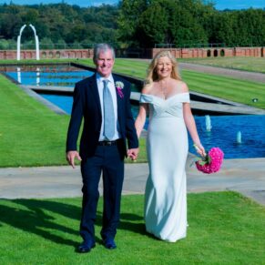 The couple take a walk near to the lovely water feature in the hotel's grounds on their wedding day