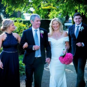 The newlyweds taking a stroll under the shade of the trees with their children