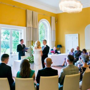 Wide view of the civil ceremony in progress captured from the back of the room at The Grove m