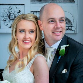 Portrait photography of the newlyweds lit through the big window in the grand entrance of the White House at their Beaumont Estate wedding