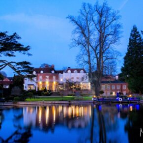 A romantic night shot of Saint Michael's Manor across the water under dusky blue skies