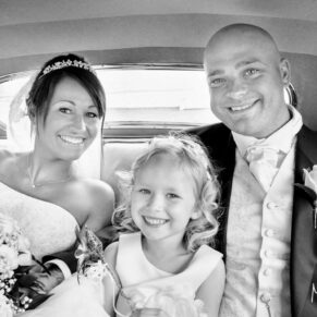Wokefield Estate Berkshire Wedding Photography - the couple with their flower girl inside the car