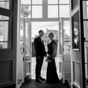 A dramatic silhouette pose of the newlyweds in the main entrance doorway of Saint Michael's Manor