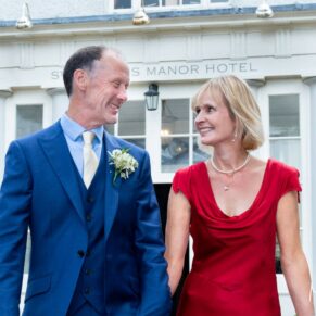 The smiling newlyweds take a stroll in front of their historic reception venue