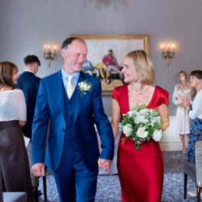 The smiling newlyweds exit their indoor civil ceremony at Saint Michael's Manor