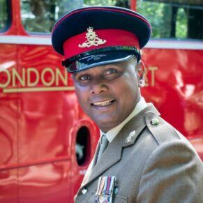 Military portrait of man captured in front of a red London bus