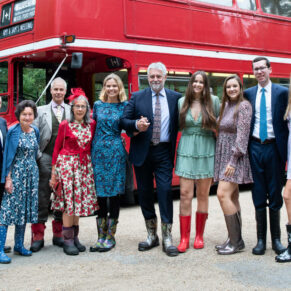 The guests arriving in a red London bus in their colourful wellies for the woodland marriage ceremony