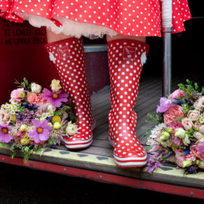 Funky wellies and flowers shot captured on the step of a London red bus