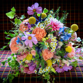 The bride’s stunning multi coloured summer bouquet placed on bus seat fabric
