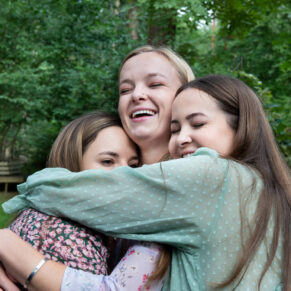 Sisterly hugs captured soon after this wonderful woodland marriage ceremony
