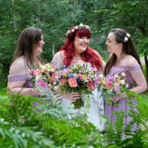 Stunning woodland backdrop for this pose of the bride with her bridesmaids captured through the ferns during the drinks reception