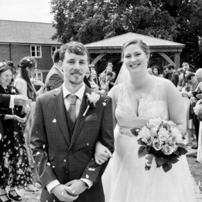 The newlyweds exit the outdoor ceremony at their Mercure Lambert Hotel wedding in Thame