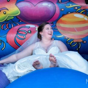 The bride taking a moment out on the bouncy castle at her Mercure Lambert Hotel wedding, Thame