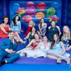 Relaxed group pose on the bouncy castle at this Mercure Lambert Hotel wedding, Thame