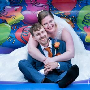 The newlyweds pose on the bouncy castle at their Mercure Lambert Hotel wedding, Thame