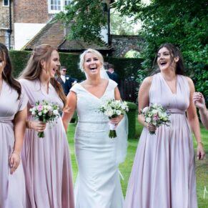 The bride walking along with her bridesmaids captured at her Grange, Northwood wedding reception