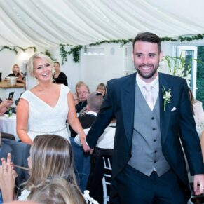 The newlyweds grand entrance into the marquee, captured at their Grange, Northwood wedding