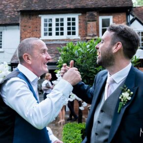 Candid moment of the groom and a friend captured at The Grange, Northwood