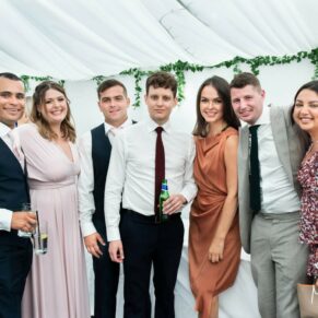 A group of friends pose for the camera in the marquee, captured at The Grange, Northwood