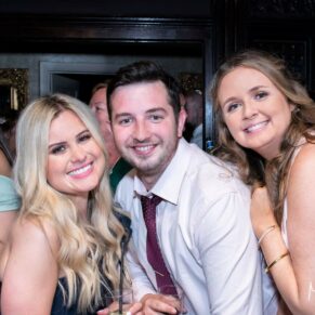 Wedding guests pose for the camera during the wedding evening reception, captured at The Grange, Northwood