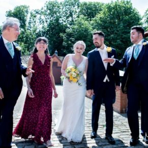 Five Arrows Hotel wedding photography of newlyweds taking a stroll with some family members