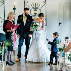 Young pageboy asking how his camera works just as the newlyweds are about to exit their civil ceremony at the Five Arrows Hotel