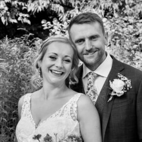 Close-up black and white wedding portrait in the gardens of the The Olde Bell Hurley of the smiling newlyweds