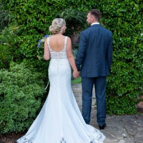 The Olde Bell Hurley Wedding Photography - the bride and groom walking away from the camera in the hotel gardens