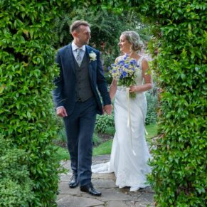 The newlyweds stroll through the garden archway at their Olde Bell in Hurley wedding reception
