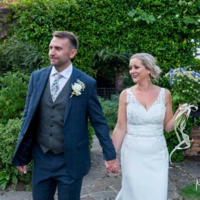 The bride and groom walking through the gardens of the The Olde Bell in Hurley on their summer's day wedding