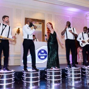 The Function Band perform from their podiums for the delighted party crowd at this Hedsor House wedding