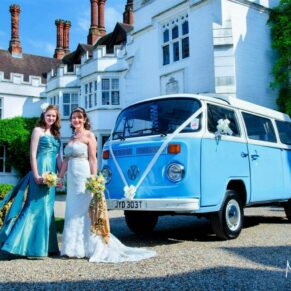 The bride and bridesmaid pose with the VW Camper at this Danesfield House fun summer wedding