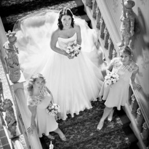 The bride on the Jacobean staircase with her bridesmaids captured from above at Hartwell House