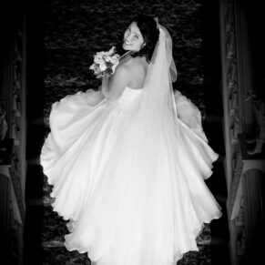 The bride on the Jacobean staircase dramatically captured from above in black and white at her Hartwell House wedding