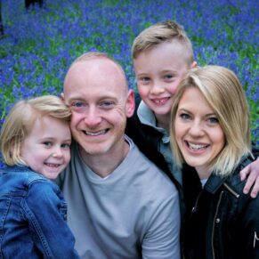 Small family group pose captured in a colourful and magical bluebell woodland in the Buckinghamshire countryside during this portraits photography session