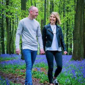 A couple walk through the bluebells in a Buckinghamshire woodland scene for their relaxed engagement portraits photography sessiony