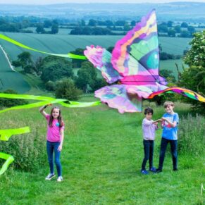This fun kite flying shot of smiling kids was captured in the Buckinghamshire countryside during a fun packed family portraits photography session